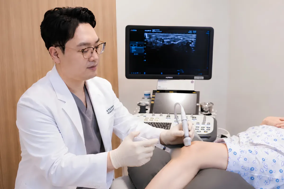 의료진이 초음파 장비로 환자 무릎에 주사 치료를 시행하는 모습